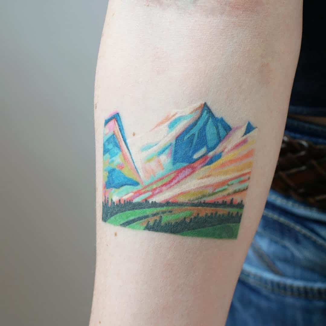 watercolor mountain tattoo on arm