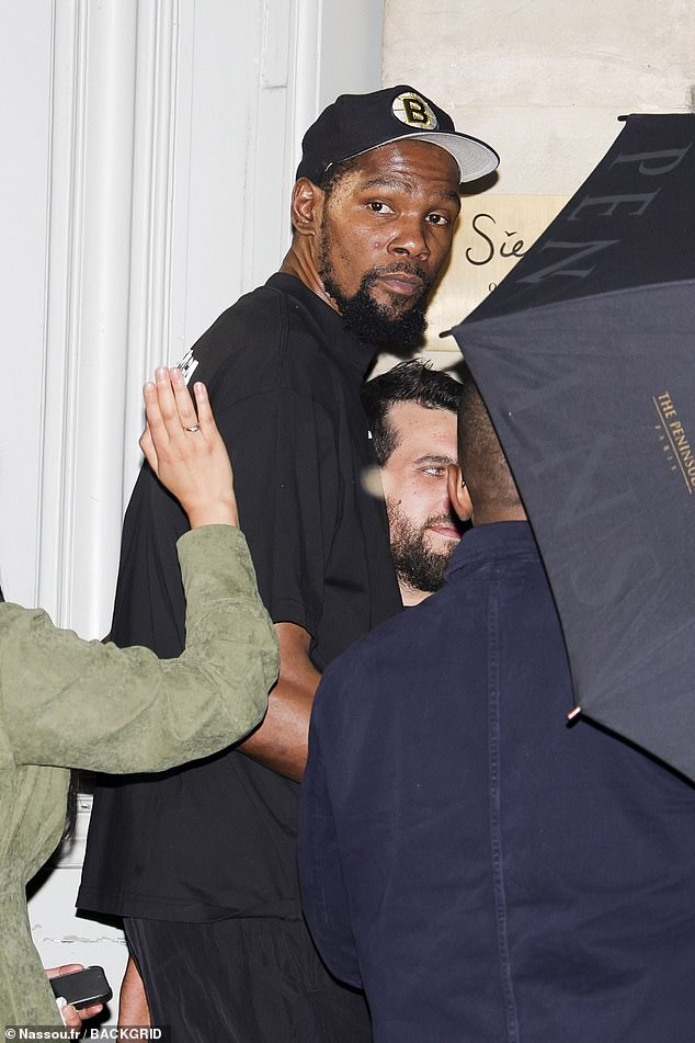 Kevin Durant sports a Boston Bruins hat as he makes his way to the exit at Siena