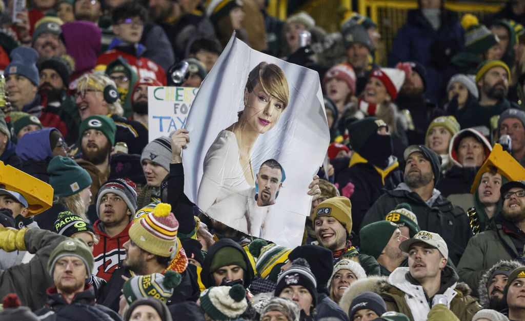 A fan held up a Taylor Swift and Travis Kielce poster during the NFL football match between the Kansas City Chiefs and Green Bay Packers on Sunday (3/12/2023), in Green Bay, Wisconsin, United States.