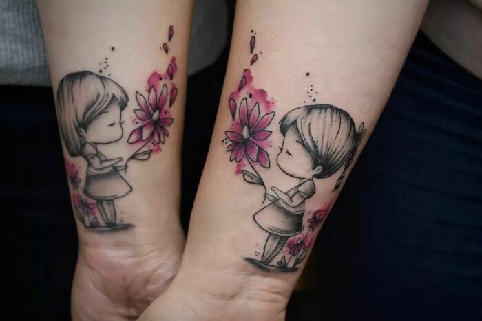 Two girls holding flower watercolor wrist tattoos